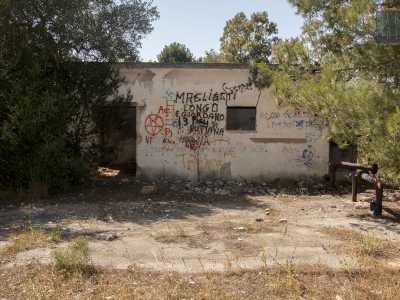 ...quando sulla destra incontriamo un primo casolare, circondato da detriti di ogni genere. Sulla facciata spiccano scritte volgari, affiancate da un pentacolo rosso, simbolo caro soprattutto ai cultori del demonio